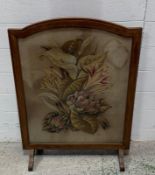 An oak fire screen with a glazed, florally embroidered panel (60cm x 78cm)