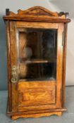 An oak smokers' cabinet with glazed door and single drawer (H40cm W22cm D19cm)