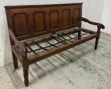A Georgian style oak bench with panelled back, downswept arms and turned front legs (110cm x 190cm x