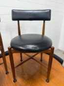 An oval G-Plan extendable table and six chairs with black leather seats and backs