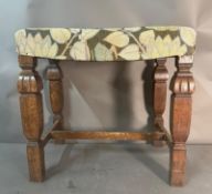 An oak footstool in floral upholstery