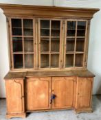 Pine dresser with three glazed doors, sitting upon four panel door sideboard below (H200cm W163cm
