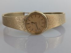 A vintage ladies Omega Quartz wristwatch with a 9ct yellow gold case and integrated mesh strap