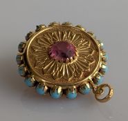 An embossed yellow gold double sided medallion with turquoise and gem-set decoration, 35mm diameter