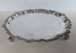 A QEII silver salver with applied pie-crust border raised on four scroll feet, hallmarked for C J Va