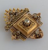 A late Victorian Etruscan-style gold brooch with diamond adornments, filigree and Greek key decor