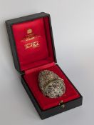 A cased Stuart Devlin silver gilt surprise egg with textured honeycomb cage work exterior