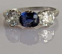 A three-stone diamond and sapphire trilogy ring on a white metal shank, the oval sapphire 7 x 5mm,