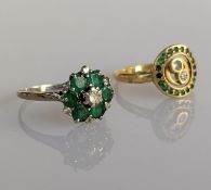 A white gold target ring with emerald and diamond decoration on a claw setting and a yellow gold