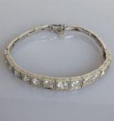 A graduated diamond articulated bracelet on a white gold setting, total diamond weight approximately