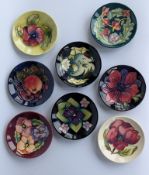 An assortment of eight Moorcroft pin dishes, various patterns, all with incised and printed marks