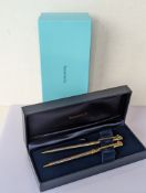 A Tiffany & Co. silver and gold tone ballpoint pen and pencil with T-clips, both signed Tiffany & Co