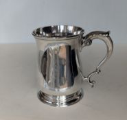 A George II silver mug of baluster form with double C scroll handle and acanthus leaf thumb-piece
