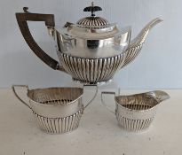 An Edwardian silver three-piece tea service with half-fluted decoration, hallmarked for Aitkin
