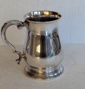 A George V silver tankard of bulbous form on a spreading foot, hallmarked for A & J Zimmerman