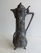 An Art Nouveau WFM pewter claret jug with hinged lid on splayed feet, 35 cm H, stamped, dent to base
