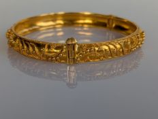 A yellow gold hinged bangle with intricate applied decoration, 60mm, stamped for 21ct gold, 22.7g