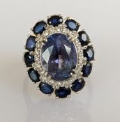 A 5.24 carat tanzanite, diamond and sapphire cluster ring, the oval bluish/violet tanzanite 
