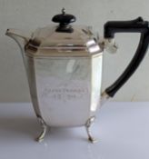 An Art Deco silver coffee or hot water pot with canted corners, bakelite handle/knop, raised on four