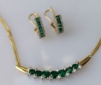 An emerald and diamond integrated necklace on a white and yellow gold setting