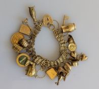 A gate-link charm bracelet with heart locket, to include a mounted George V gold half sovereign