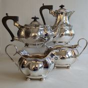 An Edwardian silver four piece tea service, including hot water pot, ebonized handles/knops