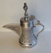 An Omani embossed Dallah coffee pot with carved finial of waisted form, unmarked but tests for 900 
