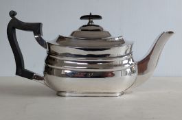 An Edwardian silver teapot with central girdle, ebonized knop and carved handle on a raised base