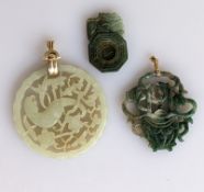 Three oriental green jade pierced and carved pendant, two with gold mounts, 55, 50, 35mm (3)