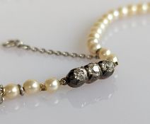 A single row pearl necklace, graduating from 3.2 to 5.7, strung without knots, on a three stone diam
