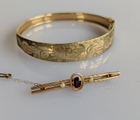 An oval yellow gold hinged bangle with etched decoration, 65mm, and an Edwardian yellow gold brooch