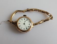 A 1920s ladies manual wristwatch with Roman numerals, gold case and elastic strap, both hallmarked 