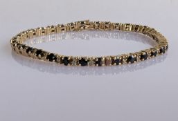 A sapphire and diamond line or tennis bracelet with box clasp, 17 cm, stamped 9ct, 10g