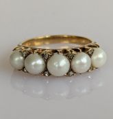 An Edwardian pearl and diamond ring on a yellow gold setting, each of the five pearls