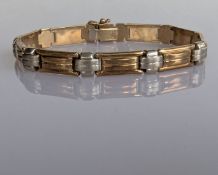 An Italian yellow and white gold articulated bracelet, 18 cm, import mark for 9ct, 10.3g