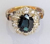 An oval sapphire cluster ring on a yellow gold claw setting, the sapphire 10 x 8mm
