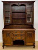 An early 20th century oak dresser with glazed doors to the top, three drawers to the base flanked by
