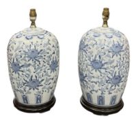 A pair of modern Chinese style blue and white globular form porcelain table lamps, with foliate
