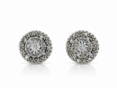 One natural round brilliant cut diamond is surrounded by a cluster of ten single cut diamonds. A