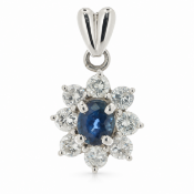 A stunning lively oval sapphire is surrounded by a cluster of eight round brilliant cut diamonds.