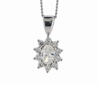 A gorgeous oval diamond is surrounded by a cluster of round brilliant cut diamonds. This stunning