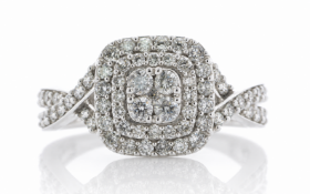 The centre cluster of four round brilliant cut diamonds is surrounded by a double halo of thirty six