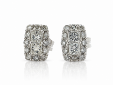 Two princess cut diamonds set one in a vertical setting is surrounded by a halo of twelve round
