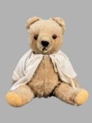 Teddybär, unbekannter Hersteller, Buckel, Glasaugen, Gesicht und Pfoten genäht, bekleidet mit Hemd,