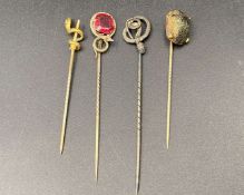 FOUR GOLD, GILT AND BASE METAL STICK PINS&nbsp;