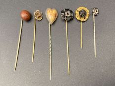 SIX VARIOUS GILT AND BASE METAL STICK PINS