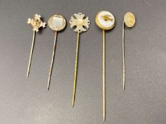 FIVE VARIOUS GILT AND BASE METAL STICK PINS