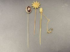 THREE VARIOUS GOLD, GILT AND BASE METAL STICK PINS