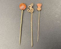 THREE VARIOUS GILT AND GOLD STICK PINS