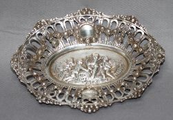 Silber. Durchbrochene kleine ovale Zierschale im Boden mit vier Putti mit Instrumenten und